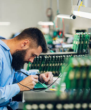 Apprentice inspecting printed circuit board assemblies